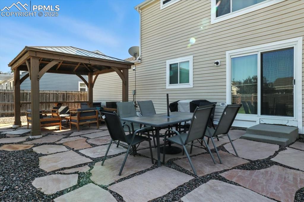 Image 20 of 33: View of patio / terrace with a gazebo and outdoor dining area