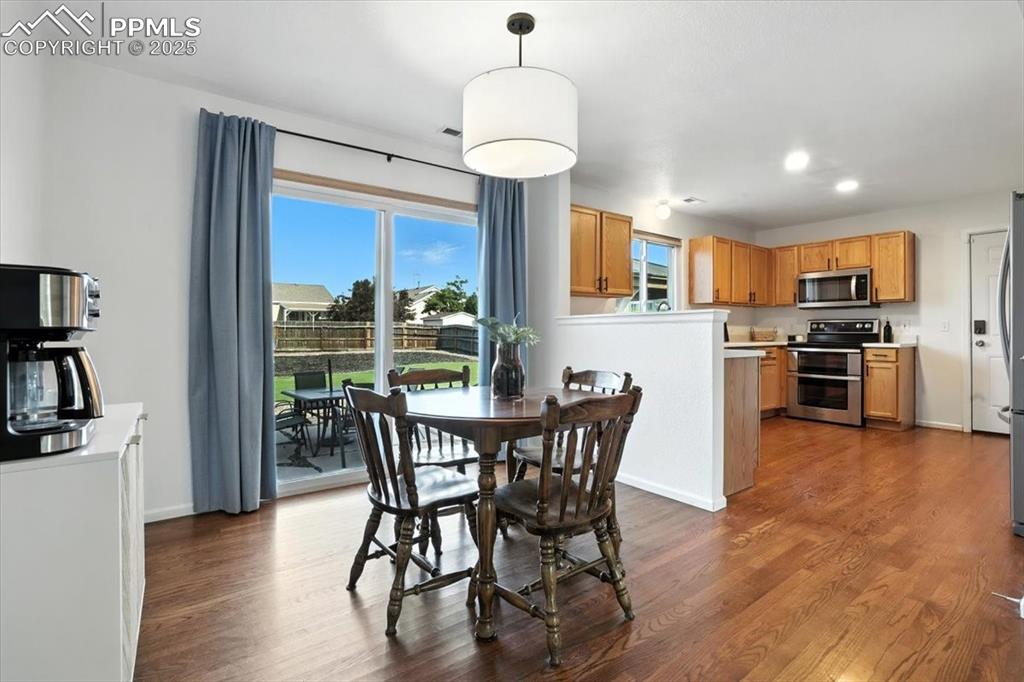 Image 5 of 33: Dining area with dark wood-type flooring and recessed lighting
