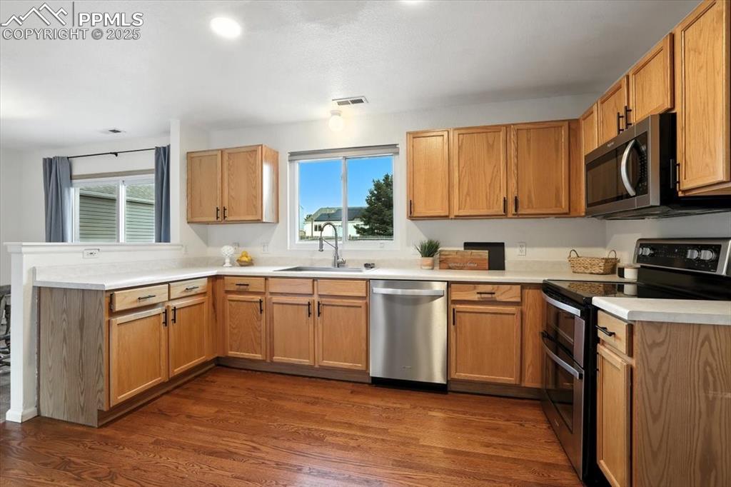 Image 8 of 33: Kitchen featuring appliances with stainless steel finishes, light counterto
