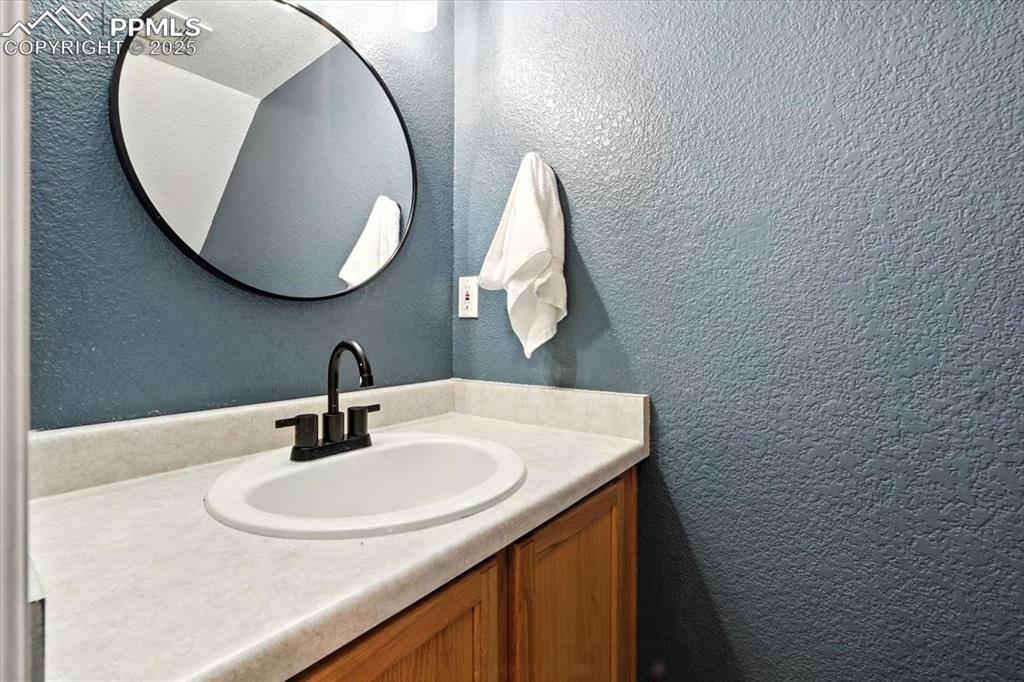 Image 9 of 33: Bathroom featuring a textured wall and vanity