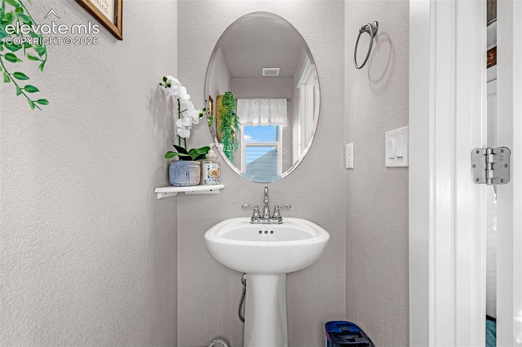 Image 10 of 37: Pedestal sink with chrome faucet, complemented by an oval wall-mounted mirr