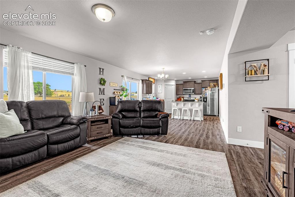 Image 11 of 37: Open-concept living area featuring wood-finish flooring, recessed lighting,