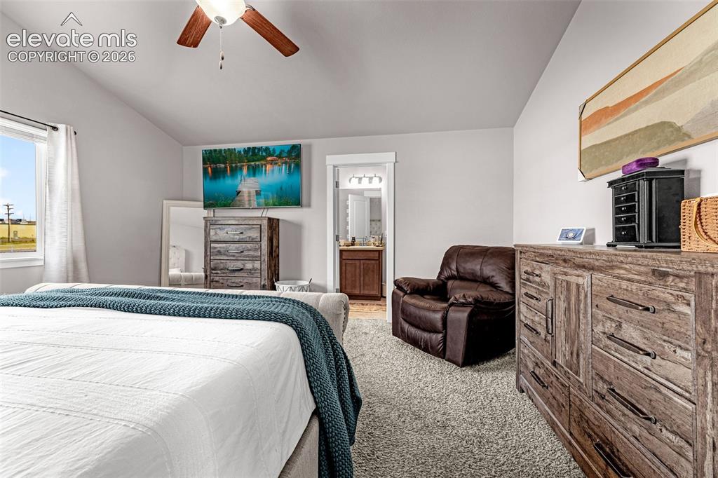 Image 20 of 37: Vaulted ceiling bedroom featuring a ceiling fan, a window with exterior vie