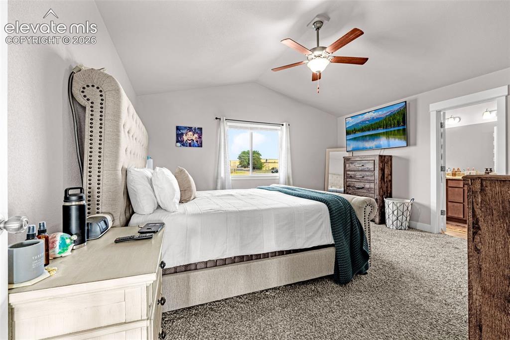 Image 21 of 37: Carpeted bedroom featuring a vaulted ceiling with a ceiling fan, a window,