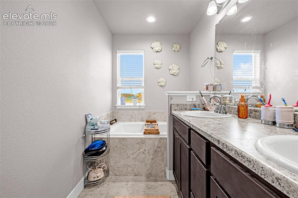 Image 23 of 37: Bathroom featuring a dual vanity with undermount sinks, dark wood cabinetry