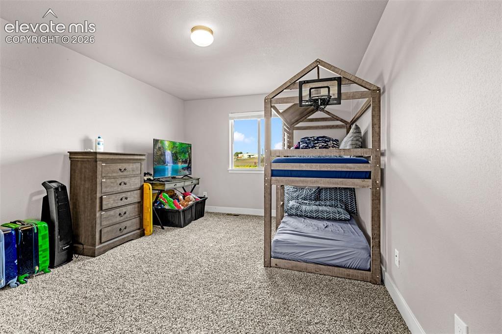 Image 32 of 37: Carpeted room featuring a window with natural light, neutral wall paint, an