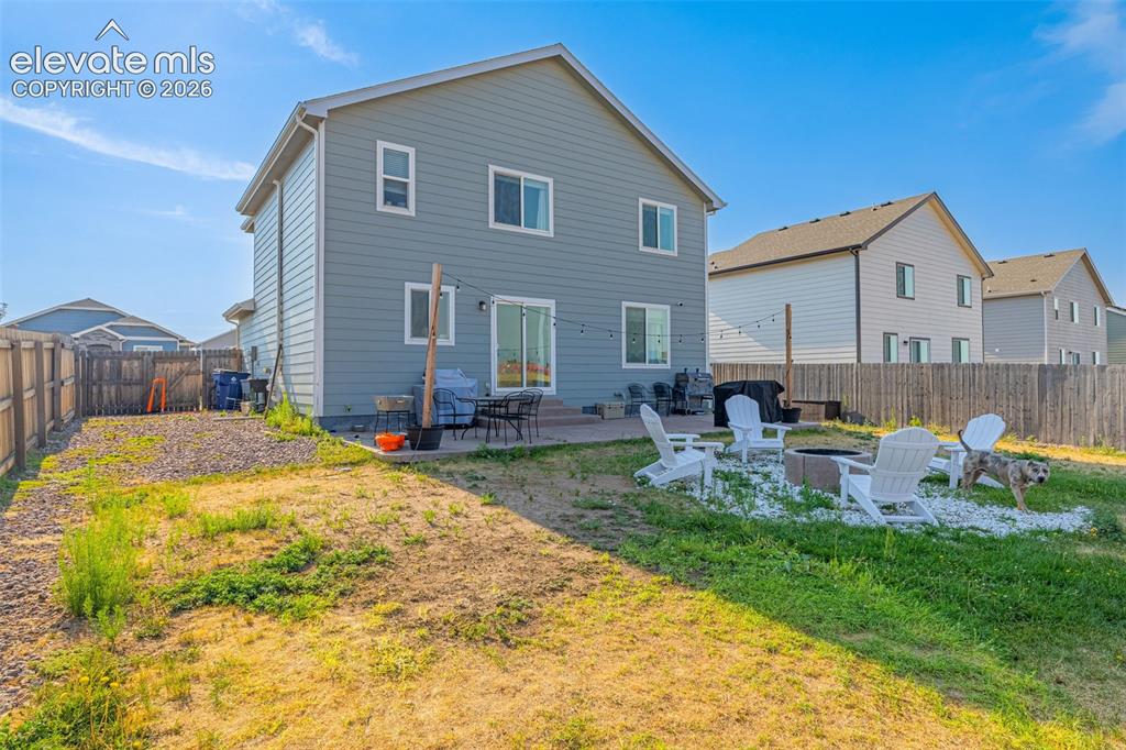 Image 35 of 37: Rear exterior featuring a sliding glass door, patio area, and fenced backya