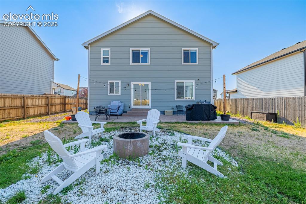 Image 36 of 37: Rear exterior featuring gray siding and white trim windows