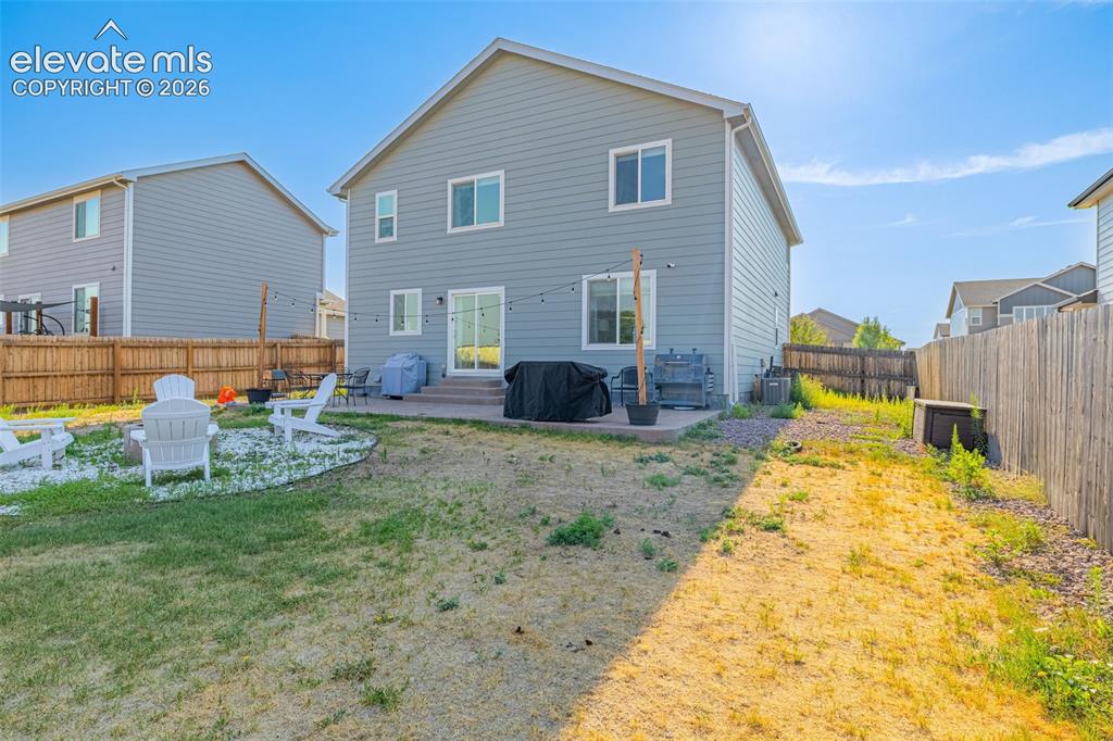 Image 37 of 37: Spacious backyard featuring a concrete patio, sliding glass door access to