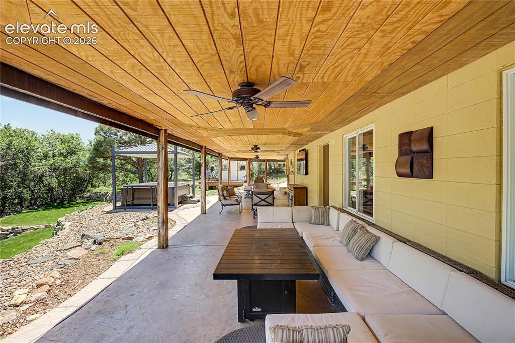 Image 39 of 50: Step outside to the covered back patio, where a beamed ceiling and ceiling