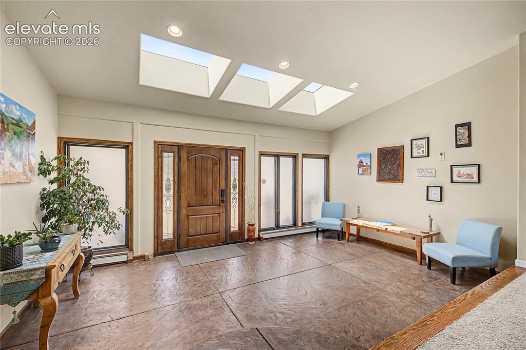 Image 4 of 50: Step through the front door into a sun-filled entryway, where three skyligh