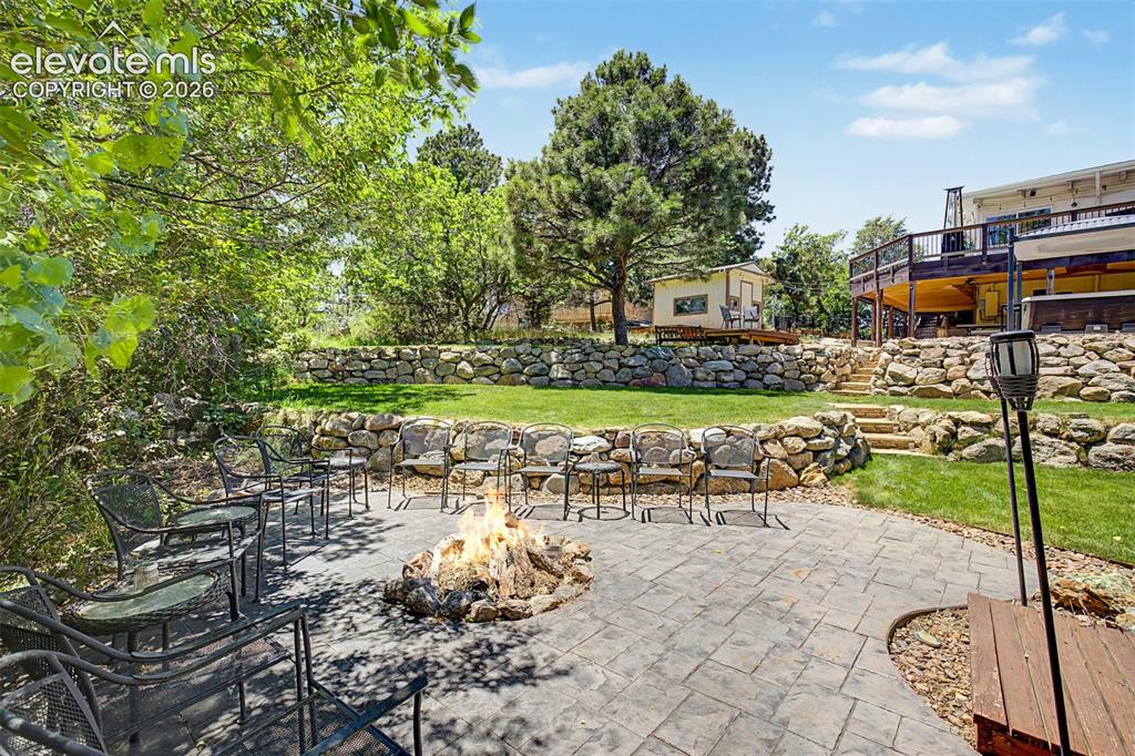 Image 43 of 50: From the patio, manicured lawns and stacked-stone walls create distinct out