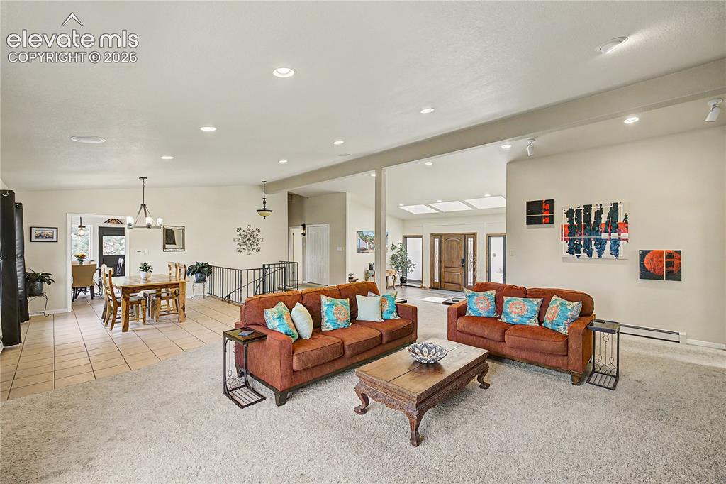 Image 9 of 50: The open living and dining areas flow into one another, separated only by a