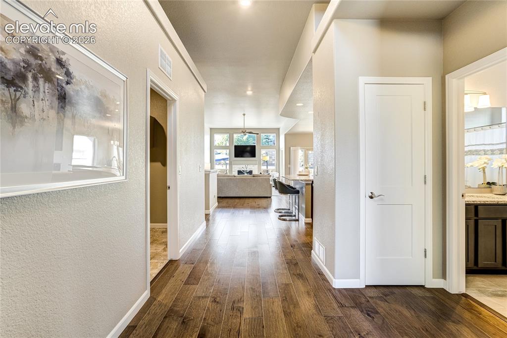 Image 8 of 48: Rich wood flooring, soaring ceilings + abundant natural light create an inv