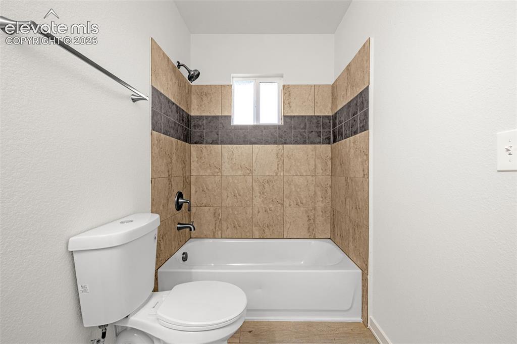 Image 14 of 50: Bathroom featuring a white tub, shower with dark bronze fixtures, and a til