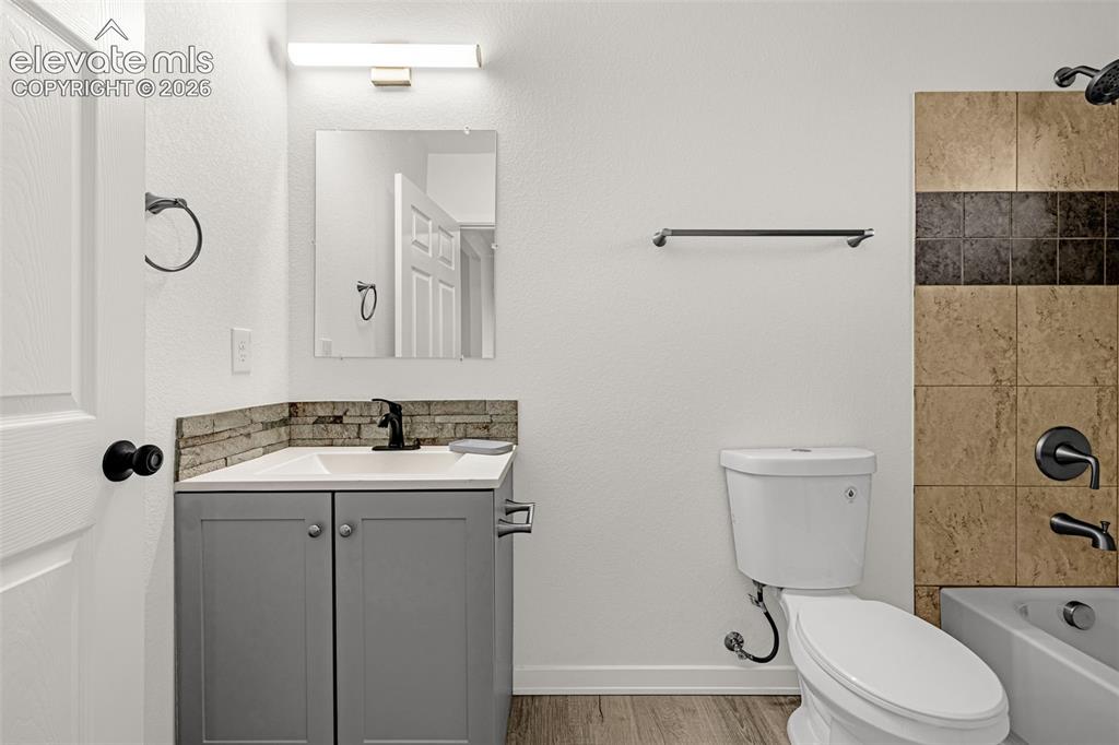 Image 15 of 50: Bathroom featuring a gray vanity with a white countertop, black fixtures, s