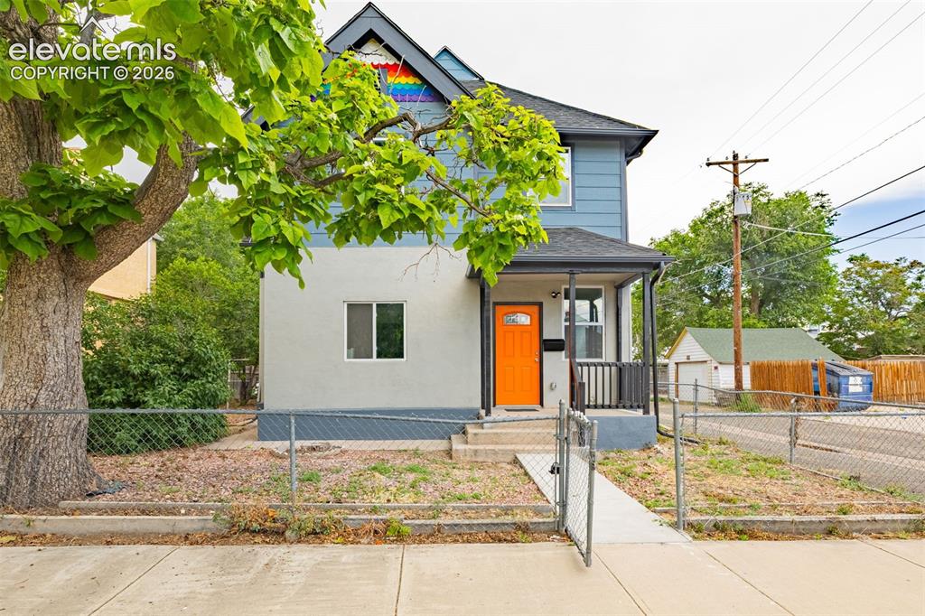 Image 2 of 50: Two-story exterior with a covered front porch featuring an orange entry doo