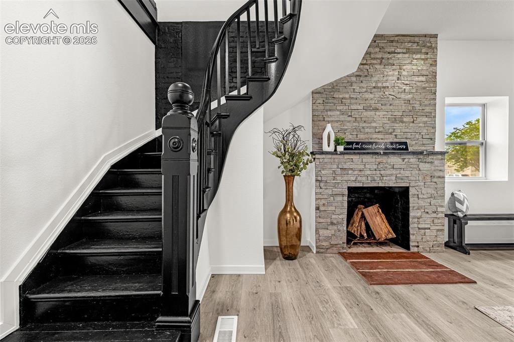 Image 22 of 50: Curved staircase with black newel post and balusters, accompanied by a stac