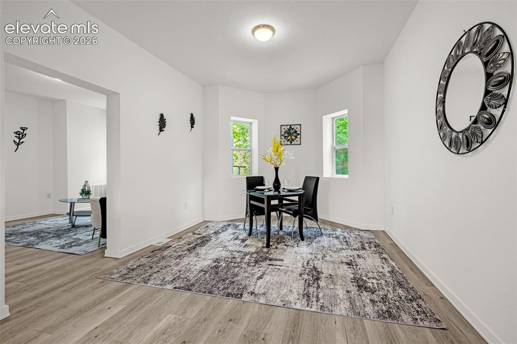 Image 26 of 50: Dining area featuring wood-finish flooring and multiple windows