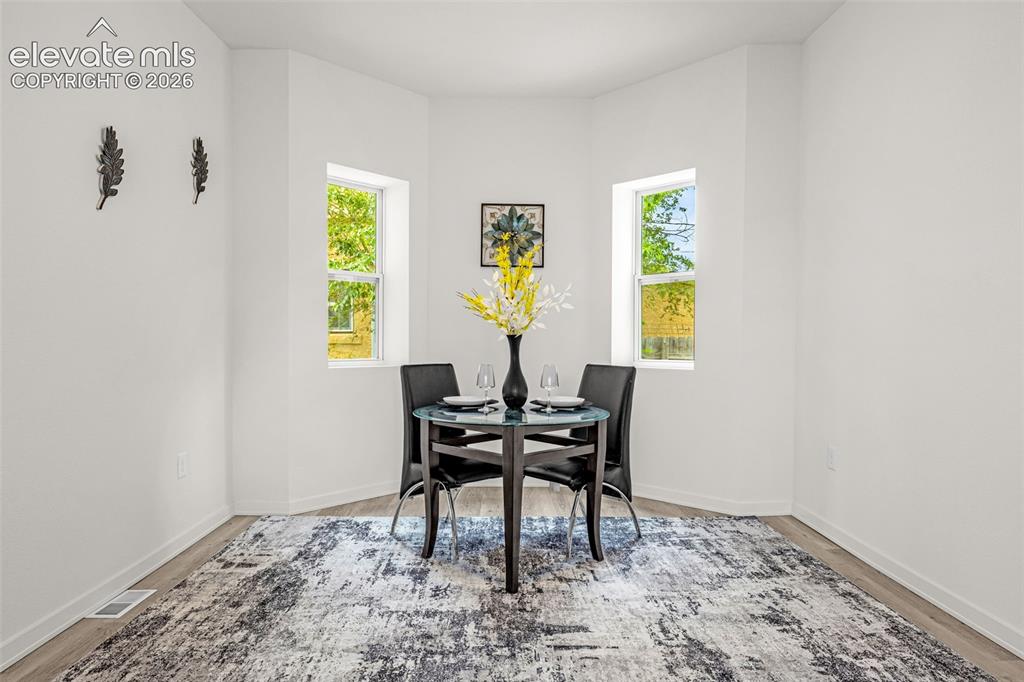 Image 27 of 50: Bright dining nook featuring two windows, wood-finish flooring, and crisp w