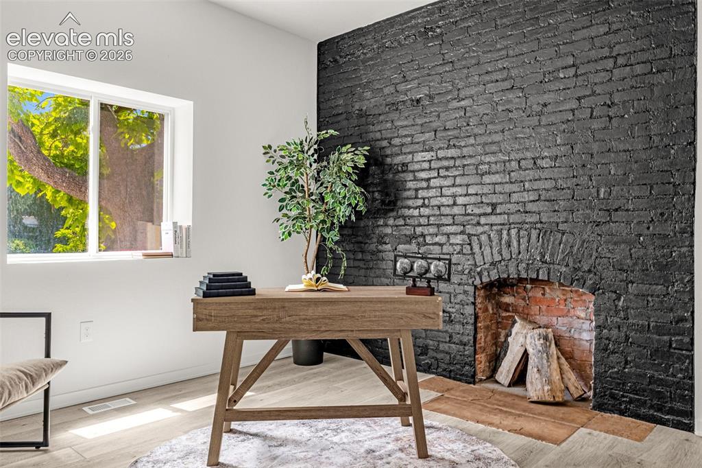 Image 3 of 50: Exposed black brick fireplace with an arched opening and contrasting interi