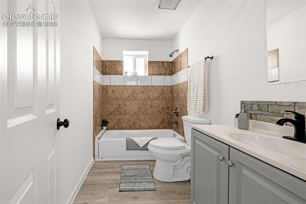 Image 35 of 50: Full bathroom featuring a single vanity with grey cabinetry, a built-in sin