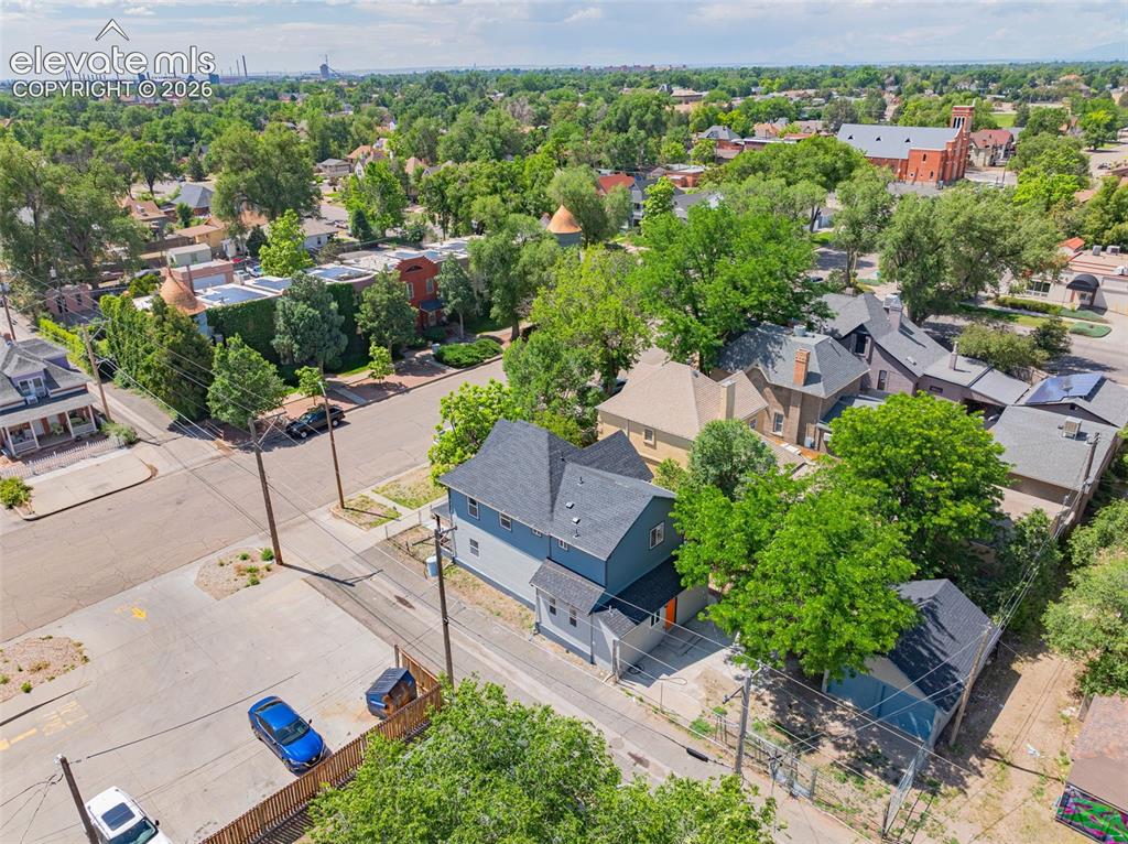 Image 39 of 50: Two-story residential structure with a shingled roof and light blue and gra