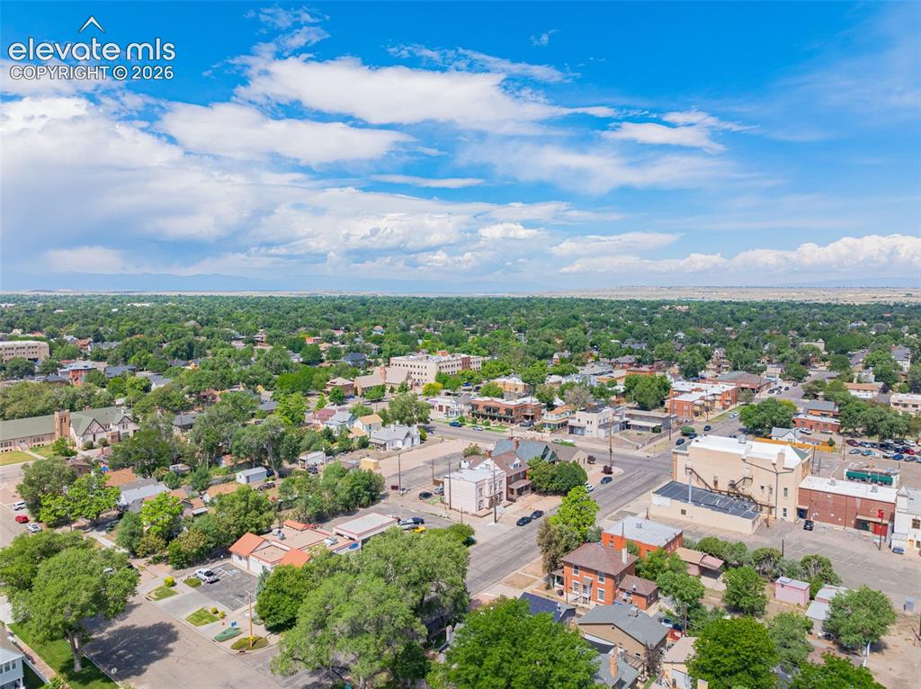 Image 44 of 50: Expansive aerial perspective showcasing a neighborhood with mature tree cov