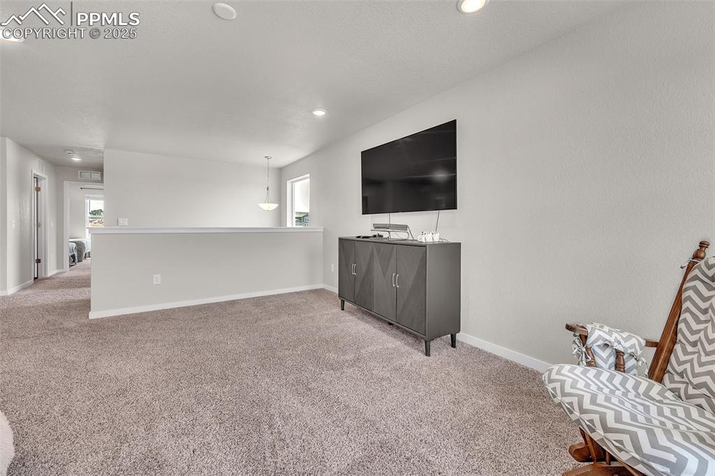 Image 21 of 50: Living area with carpet flooring and recessed lighting