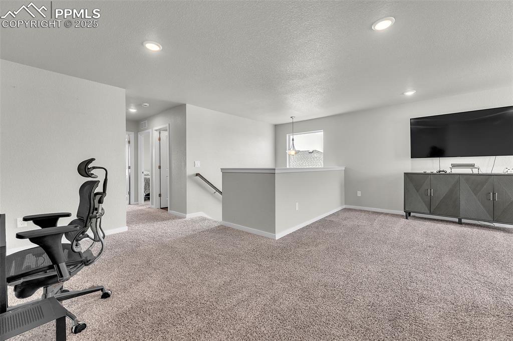 Image 23 of 50: Office space with light colored carpet, a textured ceiling, and recessed li