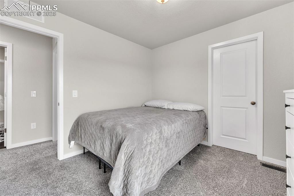 Image 26 of 50: Bedroom featuring light colored carpet