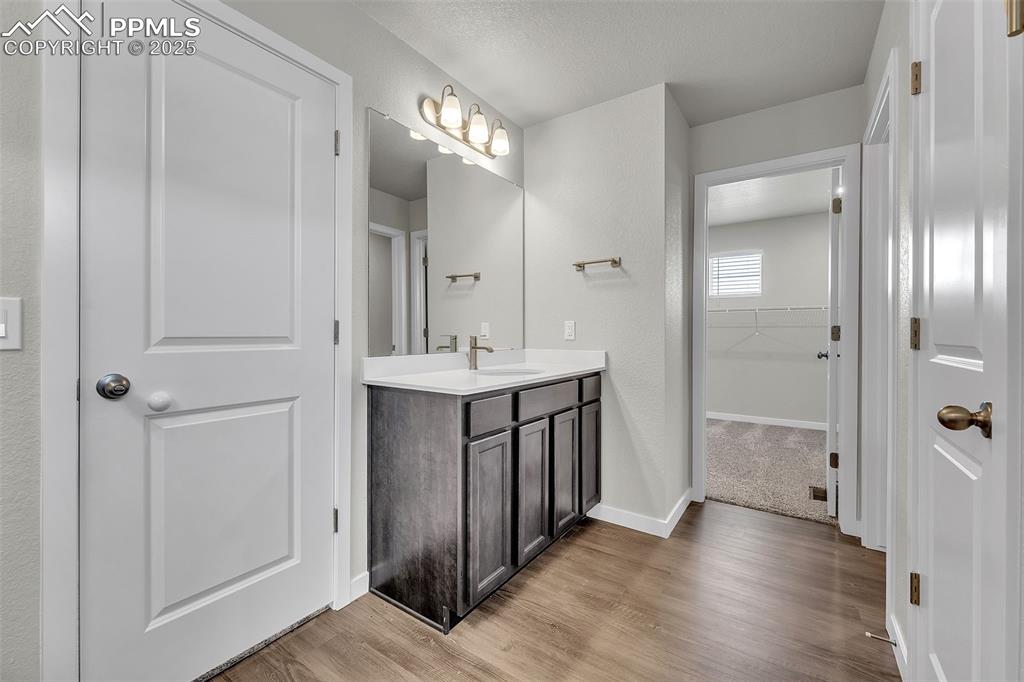 Image 31 of 50: Full bathroom featuring vanity, light wood-type flooring, and a spacious cl