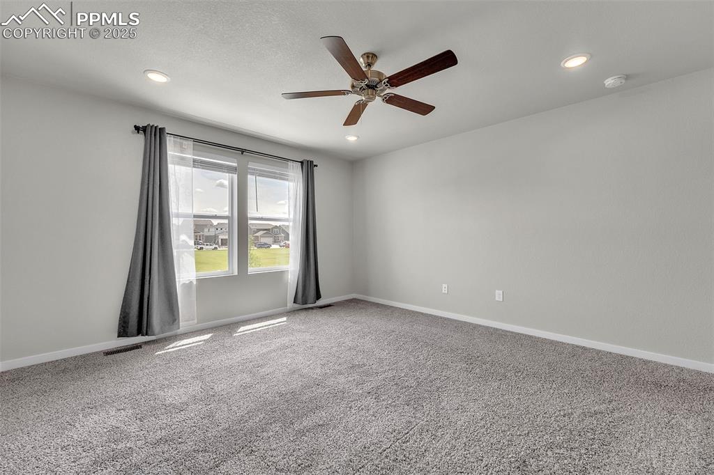 Image 35 of 50: Empty room with light colored carpet, a ceiling fan, and recessed lighting