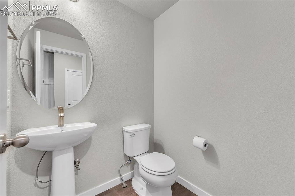 Image 37 of 50: Half bath featuring a textured wall and wood finished floors