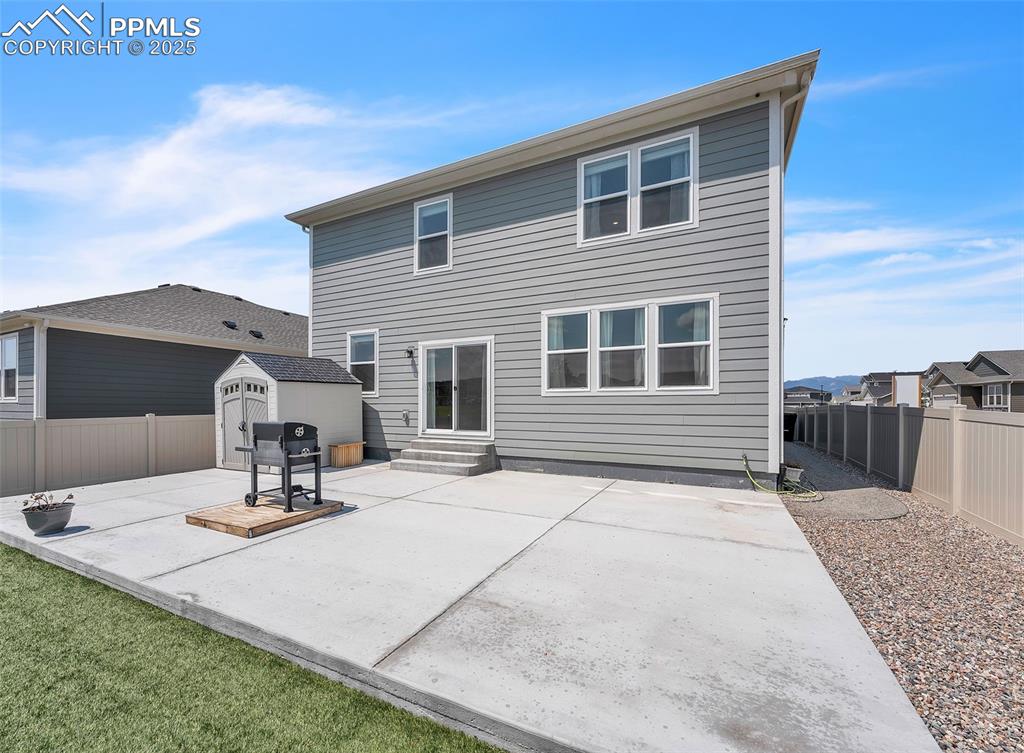 Image 42 of 50: Rear view of property with a patio, a fenced backyard, a storage shed, and 