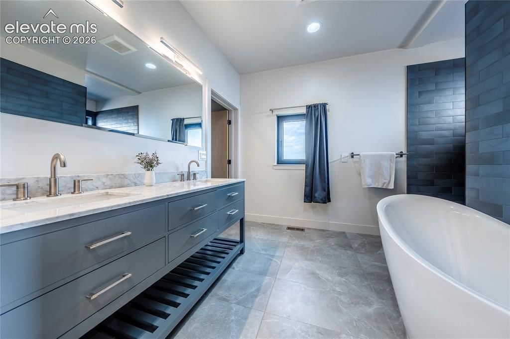 Image 16 of 49: Primary en suite bathroom with soaking tub and walk in shower.