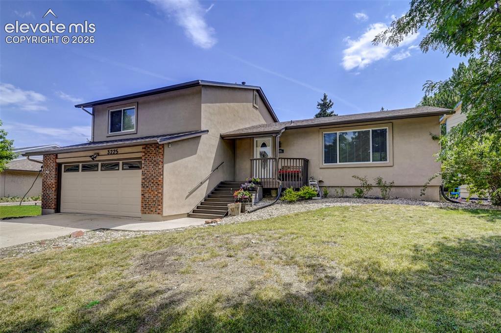 Image 1 of 49: Stucco exterior with brick accents, attached garage with panel door, front