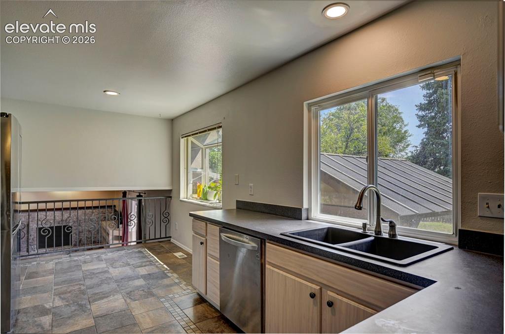 Image 13 of 49: Kitchen featuring dual windows, recessed lighting, and wood-finish cabinetr