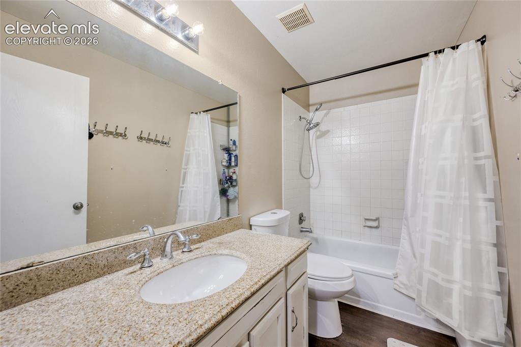 Image 28 of 49: Bathroom featuring a vanity with an integrated sink, polished chrome faucet