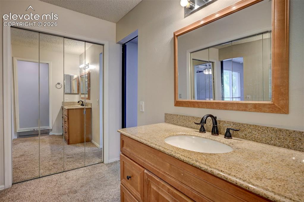 Image 31 of 49: Bathroom vanity with a light-toned countertop, an integrated sink, and an o
