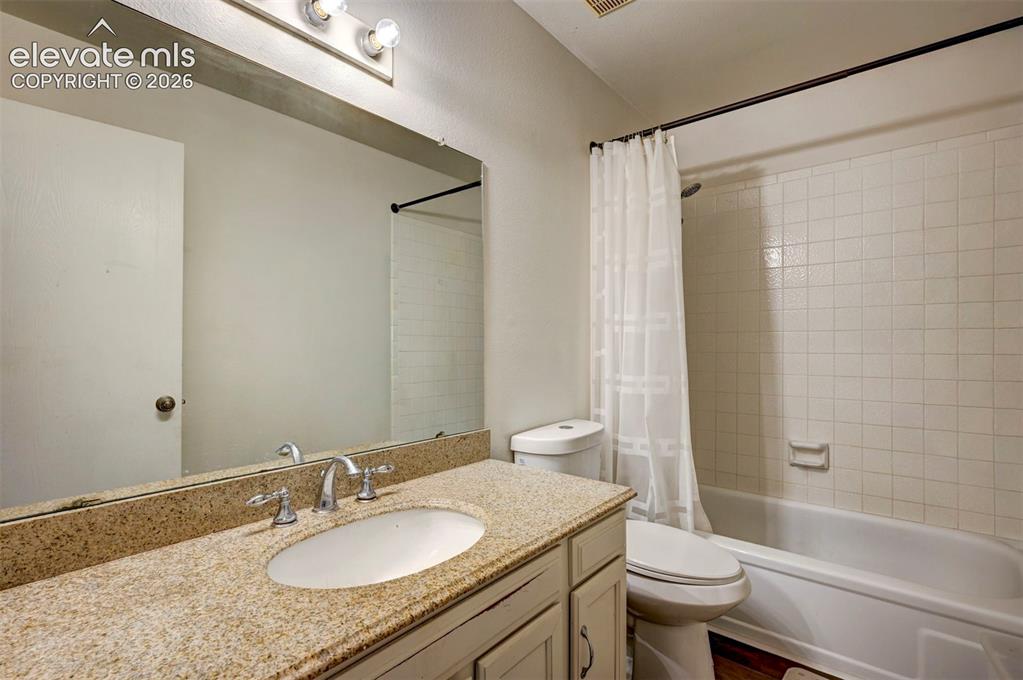 Image 34 of 49: Vanity with a speckled countertop, undermount sink, and chrome fixtures