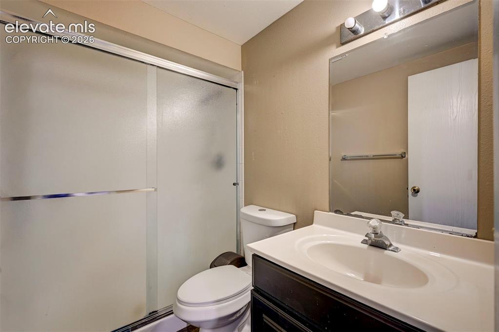 Image 39 of 49: Shower with frosted glass enclosure, vanity with integrated sink, wall-moun