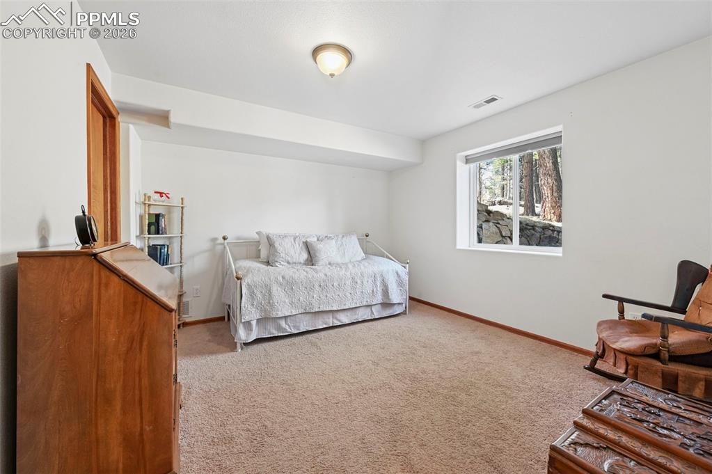 Image 15 of 25: Carpeted room with white walls, a single window, and natural wood trim arou