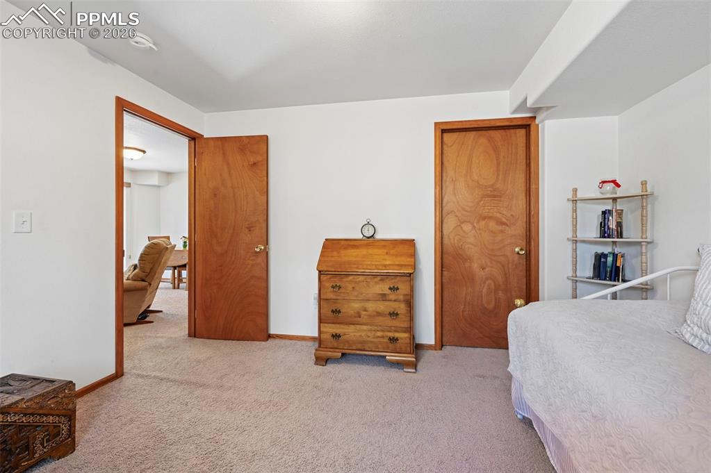 Image 19 of 25: Carpeted interior space with white walls and wood-finish trim