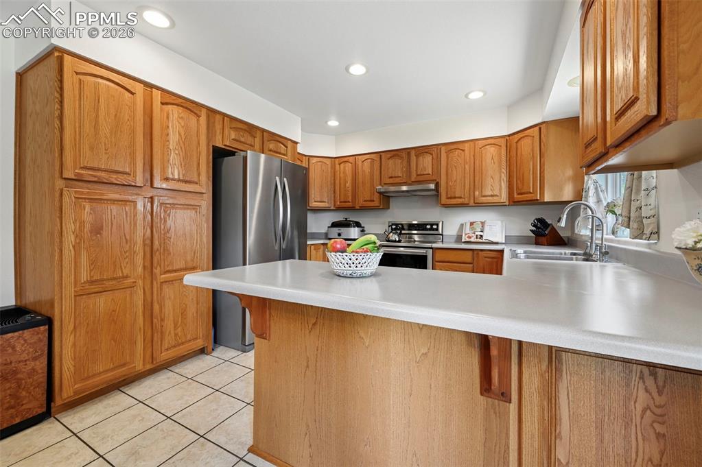 Image 2 of 25: Kitchen featuring abundant wood cabinetry, recessed lighting, white counter