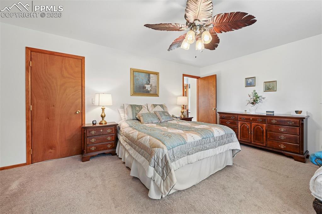 Image 20 of 25: Spacious room featuring neutral carpet flooring, a ceiling fan with decorat