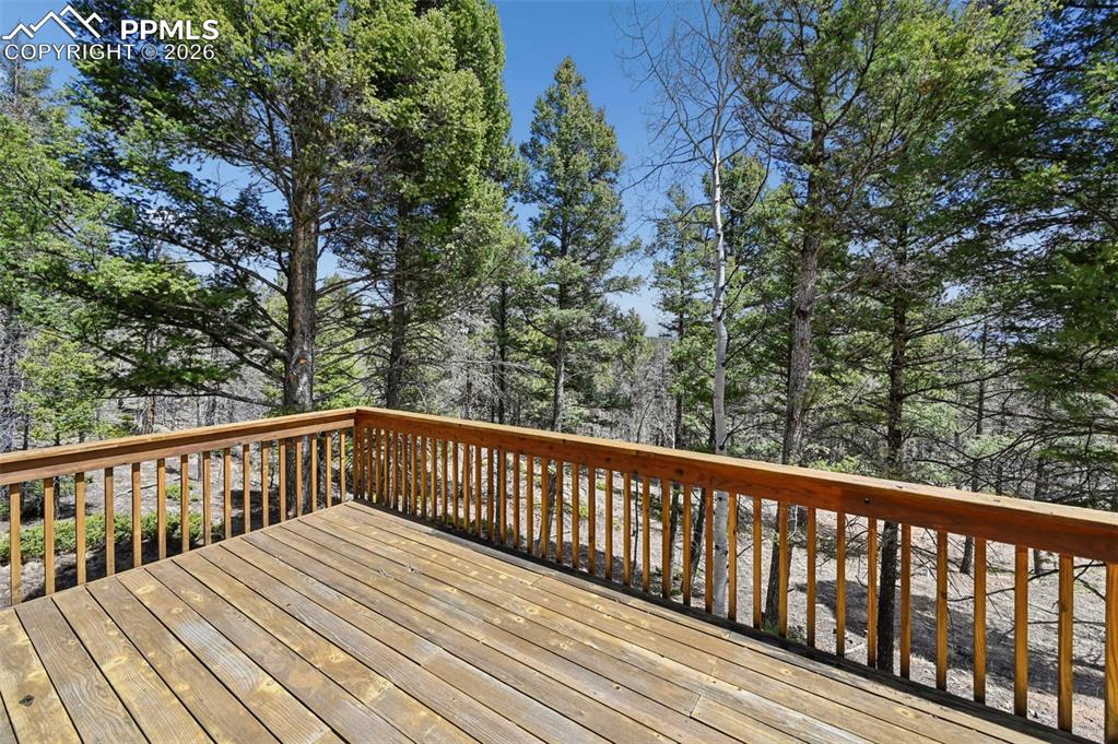 Image 22 of 25: Expansive outdoor deck featuring wood flooring and a natural wood railing
