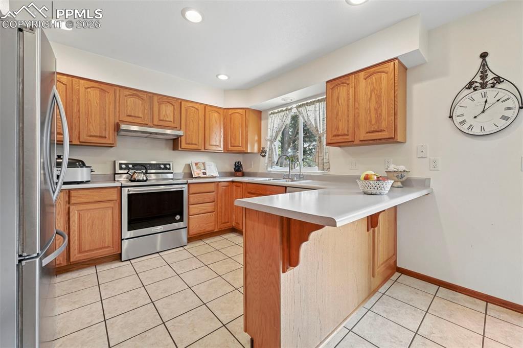 Image 3 of 25: Kitchen featuring light wood cabinetry, stainless steel appliances, light-t
