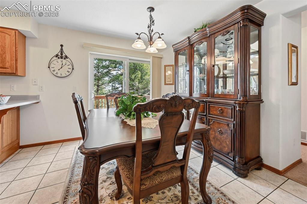 Image 4 of 25: Bright dining area featuring tile flooring, a sliding glass door, and a mul