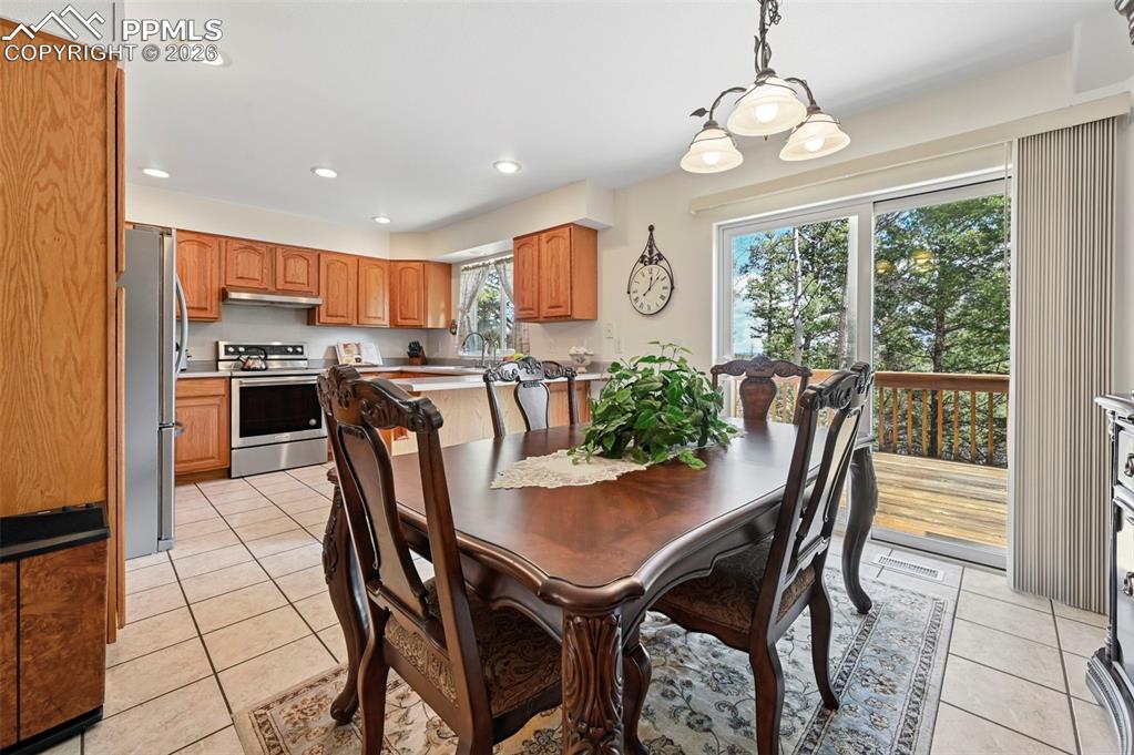 Image 5 of 25: Kitchen and dining area featuring light wood cabinetry, stainless steel app